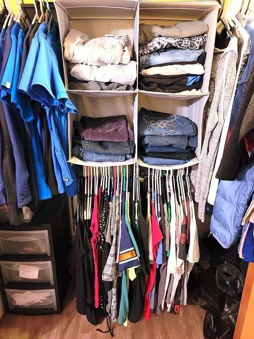 A reviewer's closet featuring the hanging organizer with clothes neatly folded across four shelves, with items hanging below