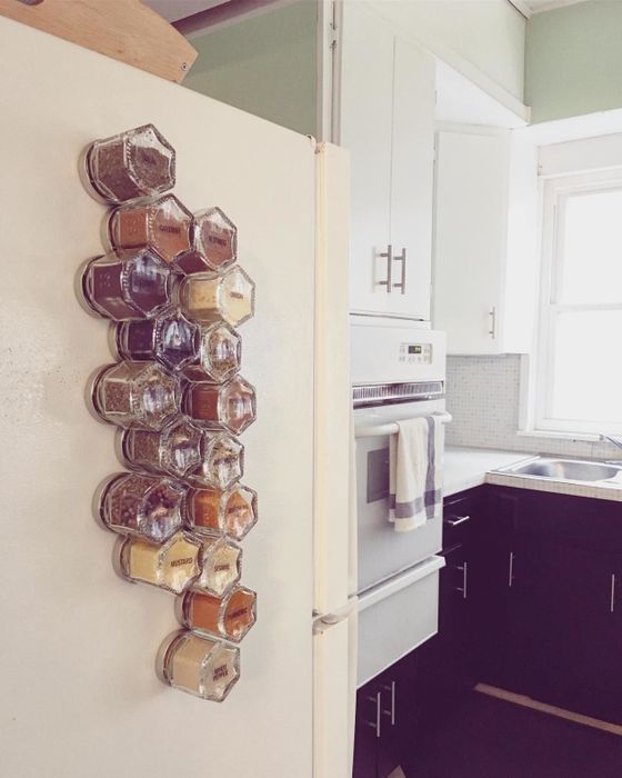 a reviewer displays their fridge adorned with 24 small magnetic jars
