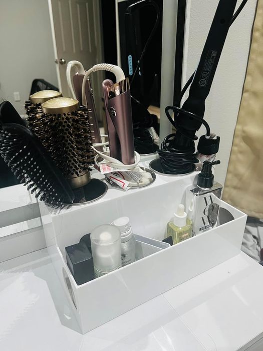 A photo of the reviewer's acrylic cosmetic organizer, filled with hair styling tools and products.