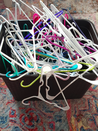 A photo showing the reviewer's pile of disorganized hangers before using the hanger stacker.