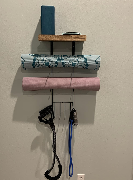 A review photo showing yoga mats and various workout equipment neatly organized on the holder.