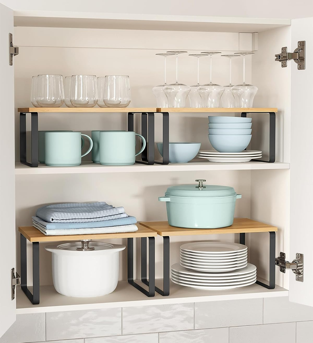 the black organizers neatly arranged in a cabinet, holding plates, bowls, and mugs