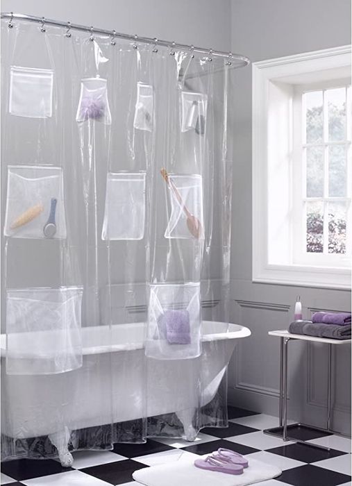 A clawfoot bathtub with a clear shower curtain organizer.