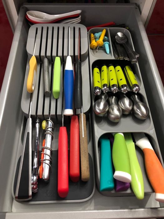 An after photo of utensils neatly organized in the drawer.