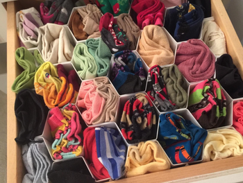 The same reviewer's honeycomb drawer organizer now filled with neatly organized socks.