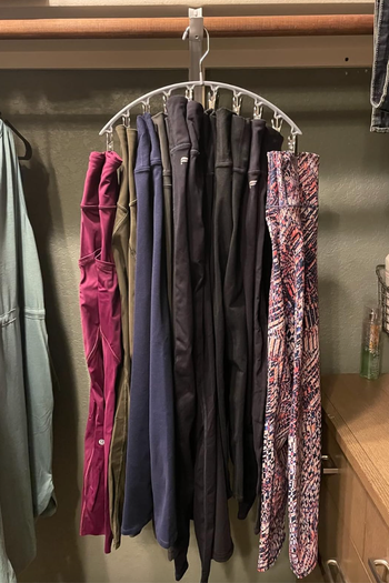 A curved hanger with ten clips, each holding a pair of leggings
