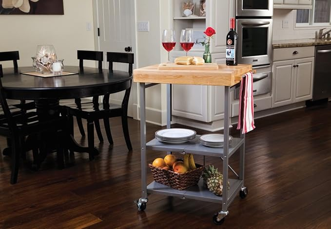 A kitchen cart featuring wine, glasses, cheese, and fruits, perfect for home gatherings. Its stylish wooden top and storage shelves combine functionality with aesthetic appeal.