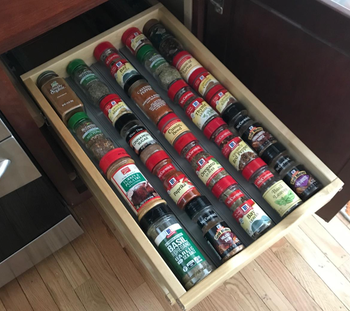 The spices now neatly arranged and organized in the drawer.