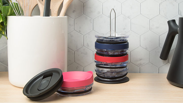 The tumbler lid organizer filled with various lids, resting on a kitchen counter.