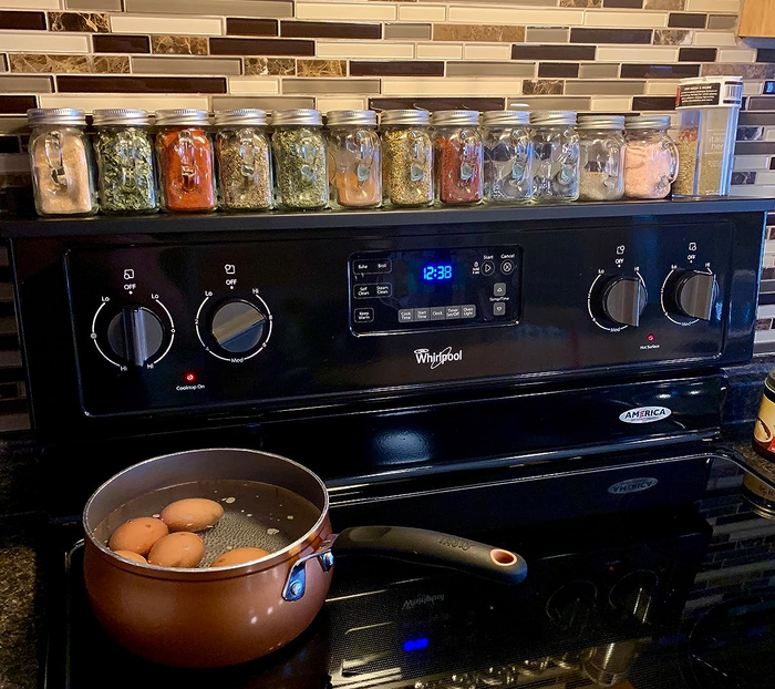 a reviewer's black stove shelf neatly holding spice jars