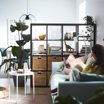 A sleek black shelf that effectively separates a living room from a dining area