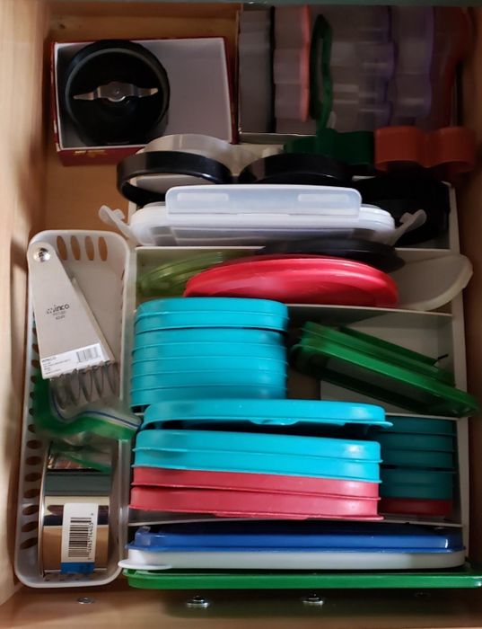 The same drawer now organized, with lids neatly arranged in the organizer