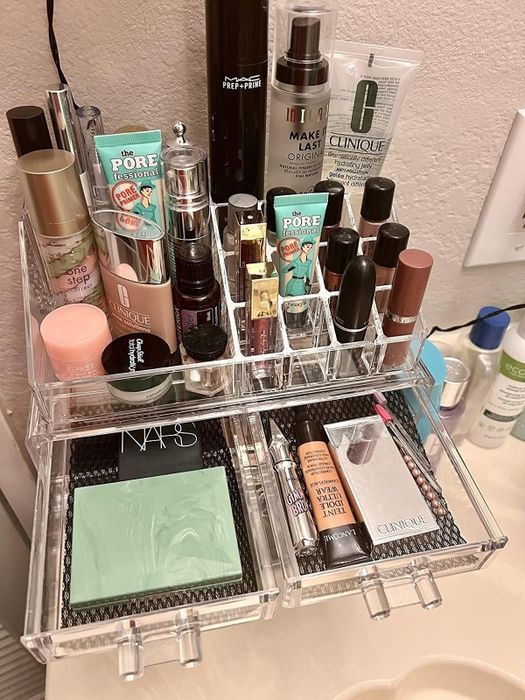 An acrylic makeup organizer that neatly arranges your skincare and makeup items, featuring popular brands like Clinique, NARS, and Benefit.
