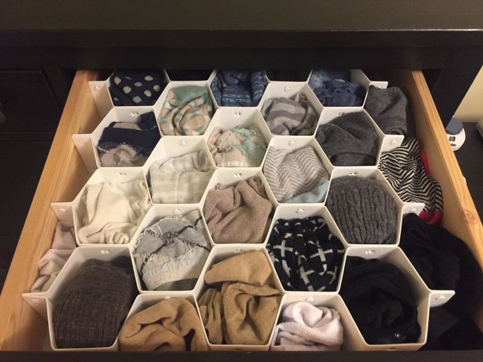 The same drawer, now perfectly organized with each pair neatly arranged in the honeycomb organizer