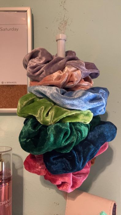 A stack of various scrunchies neatly arranged on a holder
