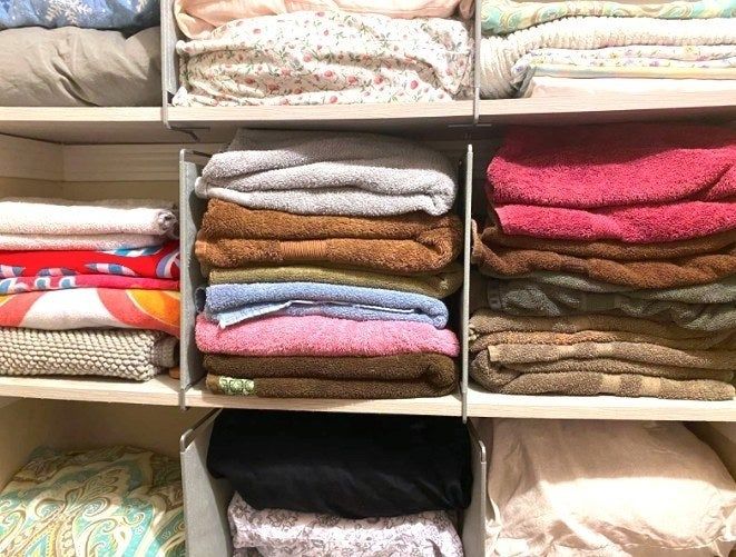 A reviewer’s linen closet using shelf dividers to separate stacks of towels