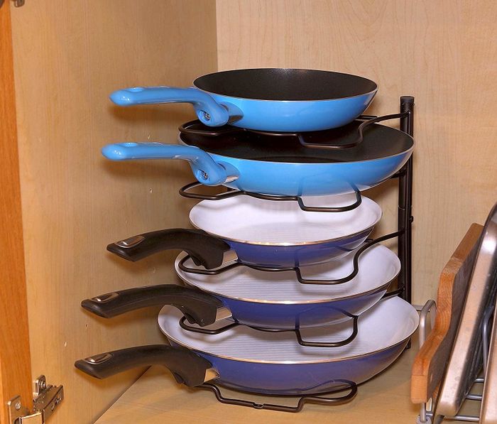 The rack standing upright with a neat stack of pans inside