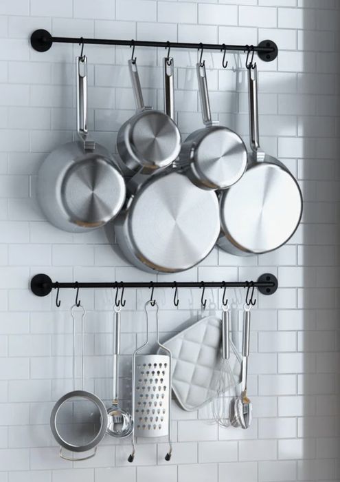Pots and pans hanging neatly from two wall-mounted pot racks.