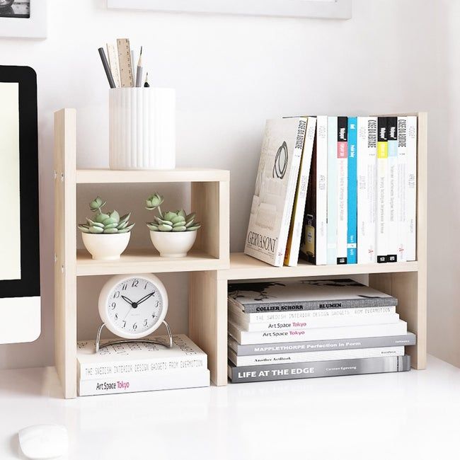 The shelf supporting books, small plants, and a pencil holder in an organized manner