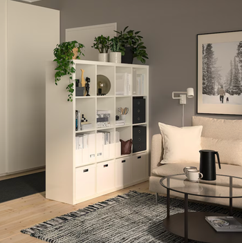 A white shelf that elegantly separates a hallway from a living room