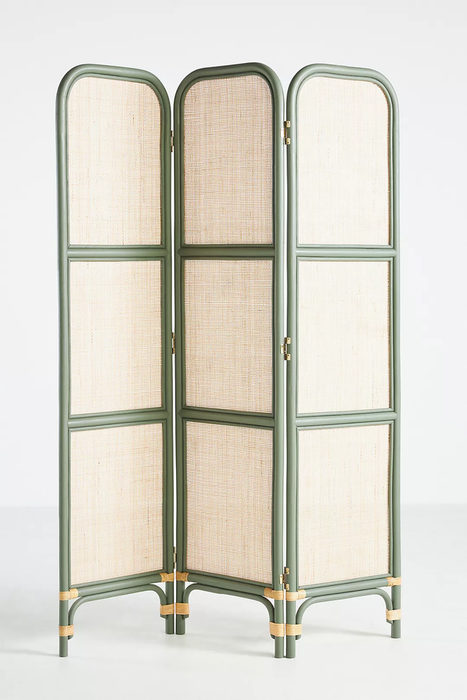 A three-panel rattan room divider in a blend of green and tan hues