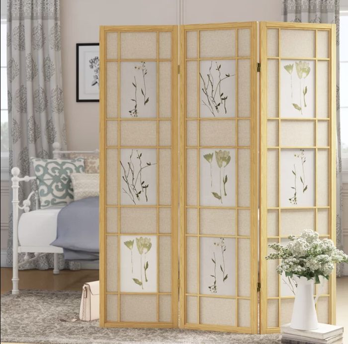A three-section room divider featuring delicate floral patterns