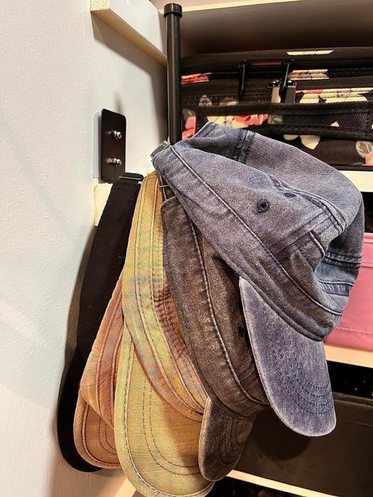 A variety of baseball caps neatly hung on a holder