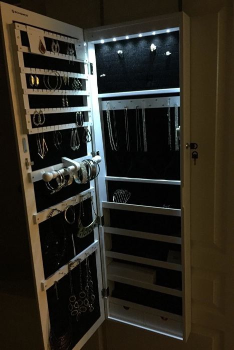A reviewer's photo showing the jewelry organizer with the door open, illuminated by LED lights