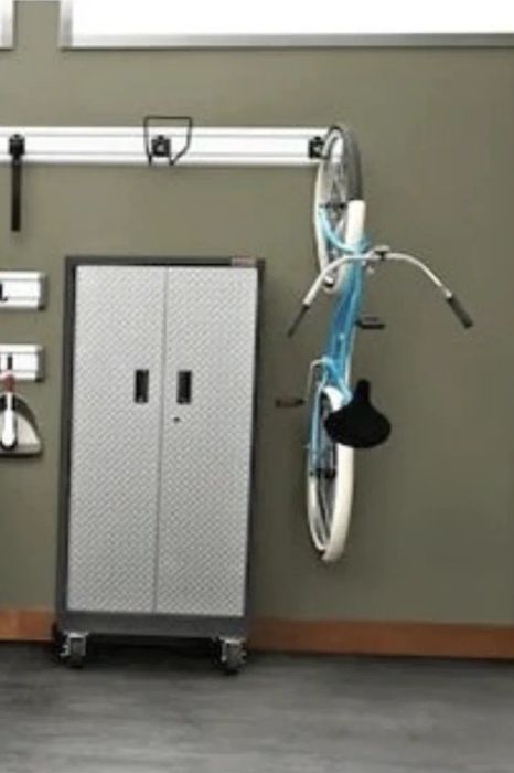 The bike securely mounted on the hook on a garage wall.