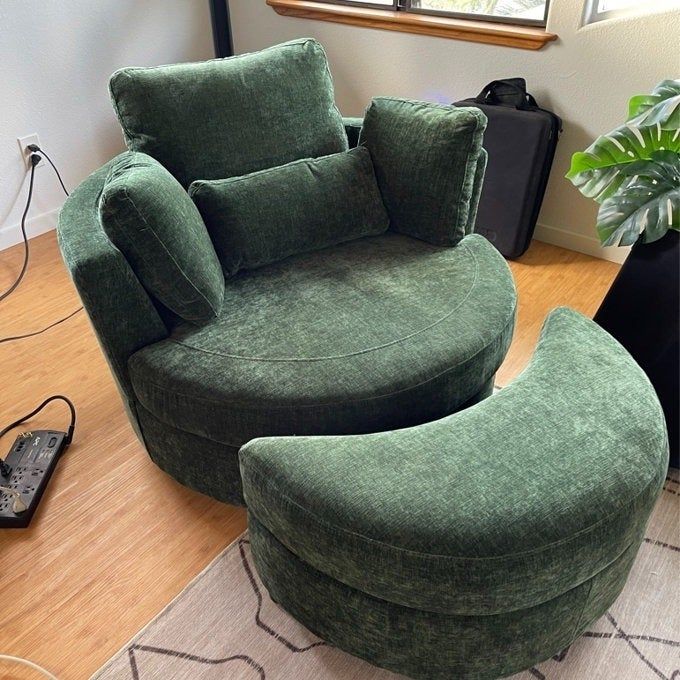 A plush green circular chair paired with a matching ottoman, featuring a modern design, set in a warm and inviting room