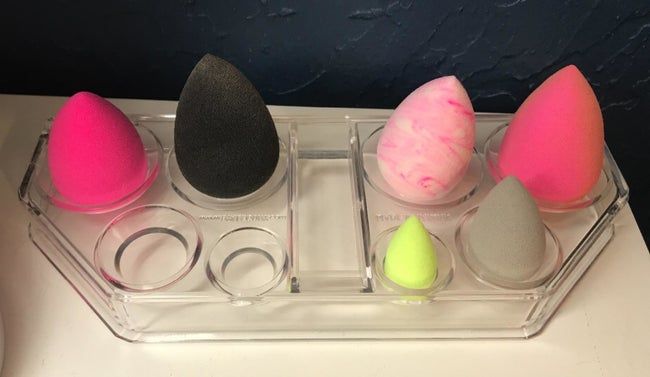 A transparent organizer with various-sized compartments to neatly store makeup sponges of different sizes.