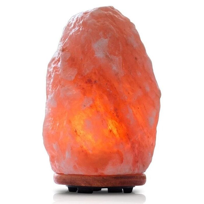 A Himalayan salt lamp on a wooden base, emitting a soft glow, showcased in a shopping article