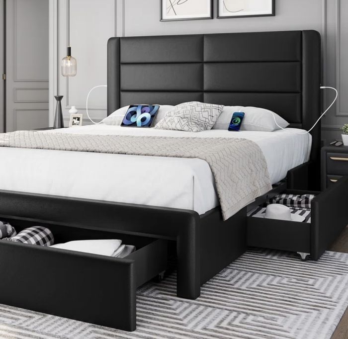 An upholstered storage bed with open drawers beneath the frame.