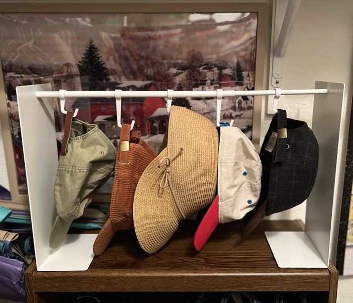a closet with a hat rack holding an array of hats