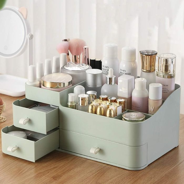 A light green vanity organizer filled with cosmetics.