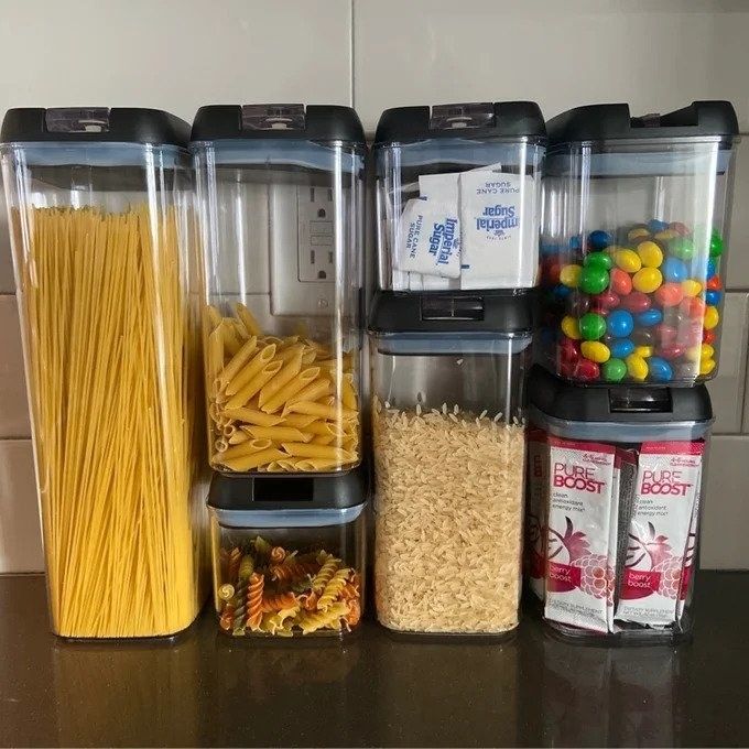 Clear storage containers with black lids, food stored inside