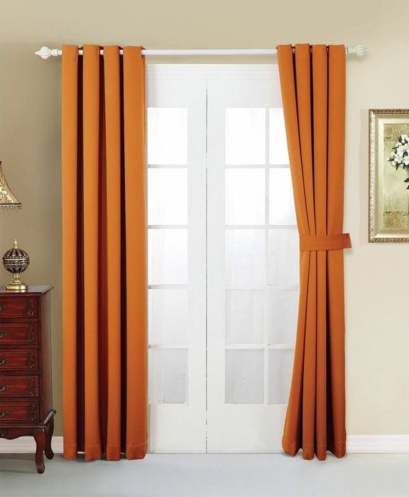 Orange curtains tied back elegantly on a window