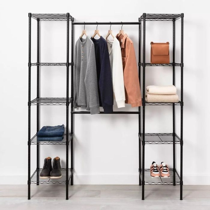 A lifestyle photo showcasing a black wire closet system with clothes and bags arranged neatly