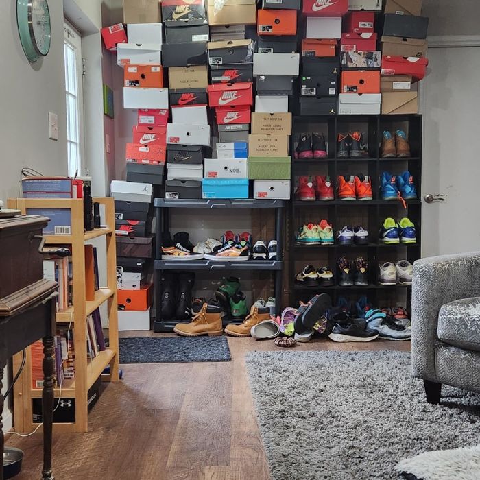 A room showcasing shelves packed with multiple pairs of shoes and stacks of shoe boxes, suggesting a dedicated display for a shoe collection