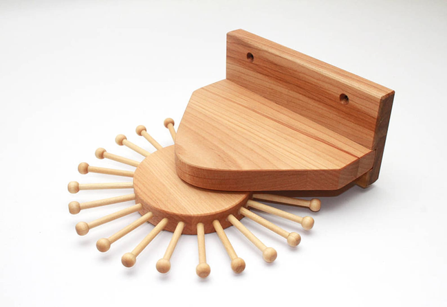 A wooden mount with 24 rotating pegs to hang various accessories.