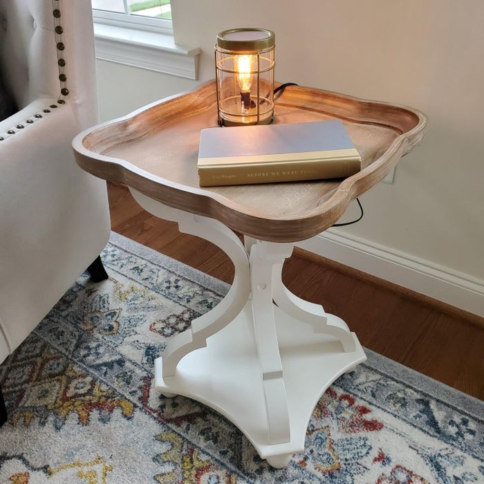Reviewer photo of the white and wood table holding a book and a lamp.