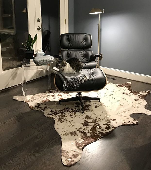A reviewer's brown-and-white faux-cowhide rug positioned beneath an armchair.