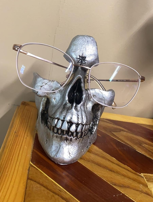 a silver skull displaying a reviewer’s glasses atop it