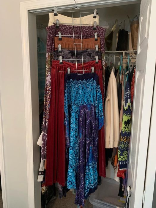 A closet door displaying multiple skirts neatly hung on a tiered hanger