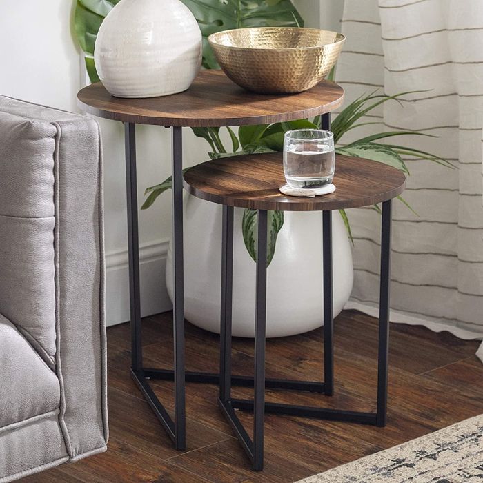 The two nesting tables, with a glass of water, bowl, and vase placed on top.