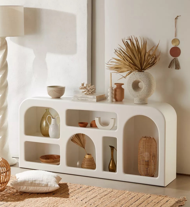 the white console filled with vases and various decorative items in its compartments