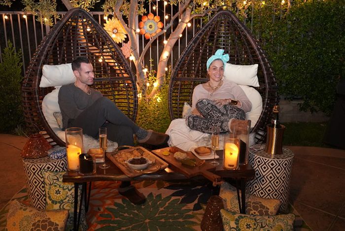 a reviewer photo featuring a couple enjoying wine and cheese while seated in two of these chairs in their backyard