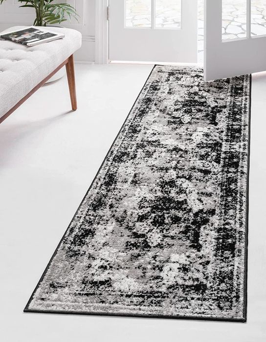 A black, gray, and white rug runner with a design inspired by vintage patterns