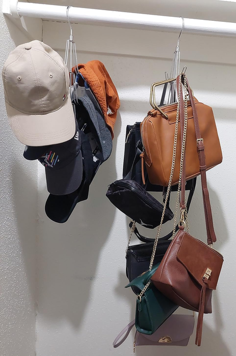 Hats and handbags neatly hanging from hooks on a closet rod