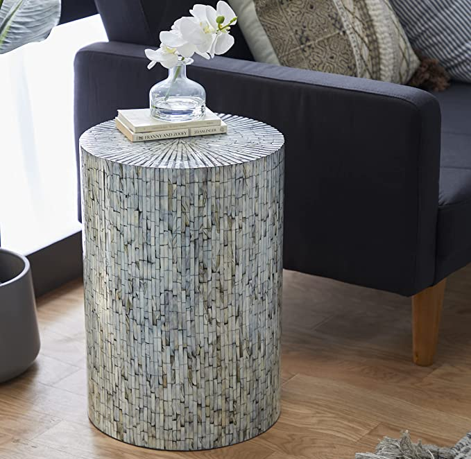 Another reviewer’s photo of a different end table design, holding a book and small vase next to an armchair.